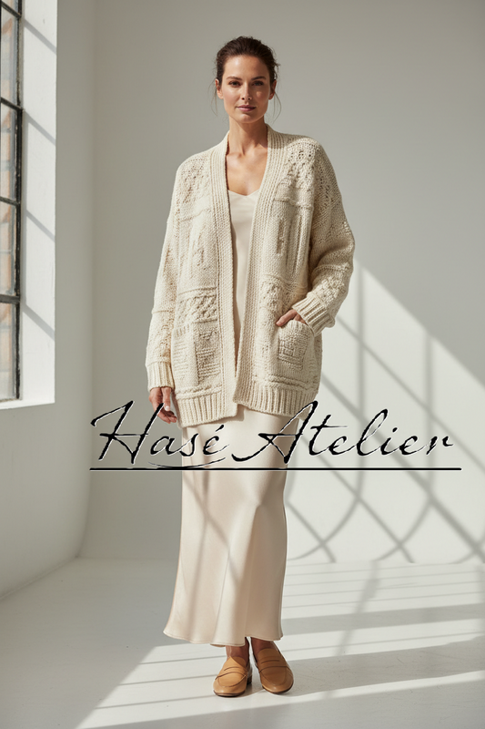 A woman stands in a bright studio wearing a cream cable-knit cardigan over a matching cream dress, with tan shoes. The words 'Hasé Atelier' are overlaid across the lower middle of the image.
